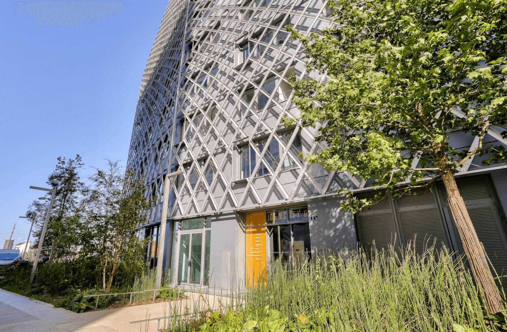 Façade moderne d’un bâtiment à Rennes EuroRennes, entouré de verdure et d’une architecture contemporaine avec des structures en croisillons métalliques
