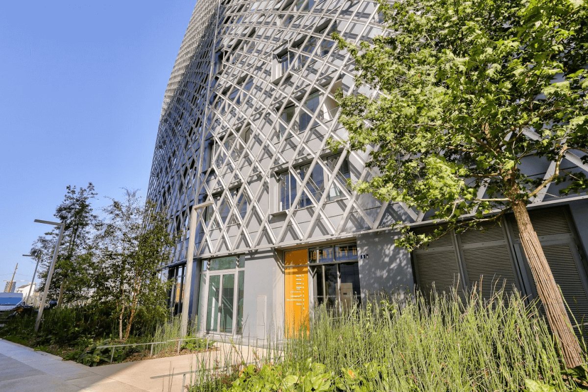 Façade moderne d’un bâtiment à Rennes EuroRennes, entouré de verdure et d’une architecture contemporaine avec des structures en croisillons métalliques