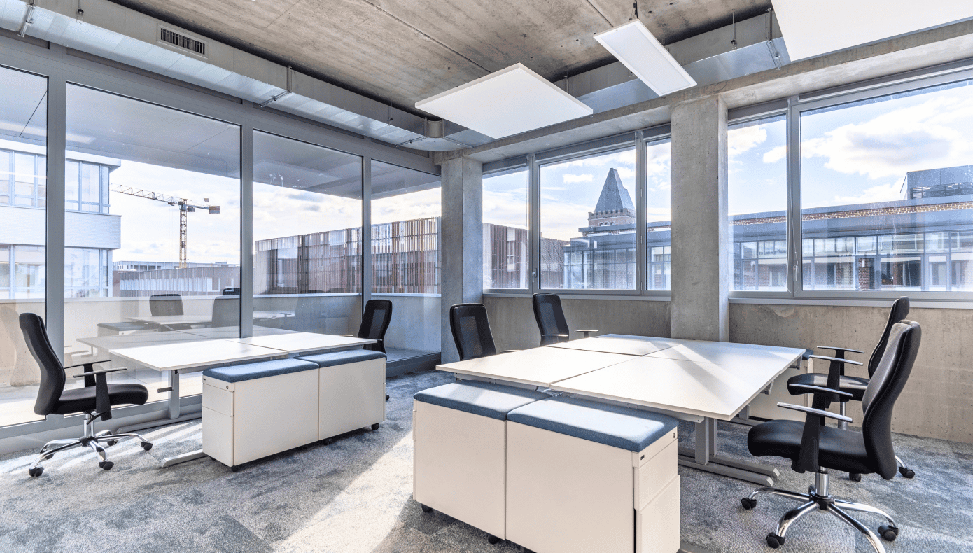 Bureau flexible lumineux à Hiptown Lille Euratech, aménagé avec plusieurs postes de travail près de grandes fenêtres.