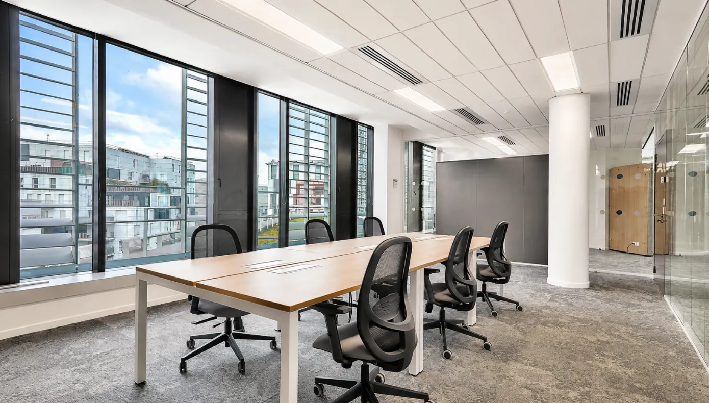 Bureaux fermés avec postes de travail, sièges ergonomiques et grandes baies vitrées à Hiptown La Villette