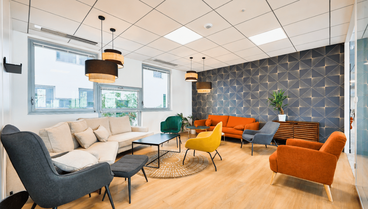 Espace détente à Part-Dieu Equinox avec canapés, fauteuils colorés, tables basses et mur décoratif.