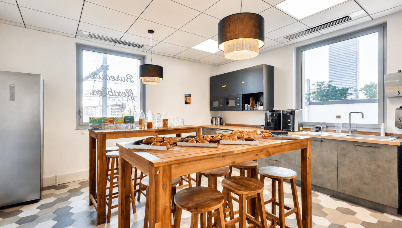 Espace kitchenette de Part-Dieu Equinox avec tables hautes en bois, assises, machines à café et comptoir équipé.