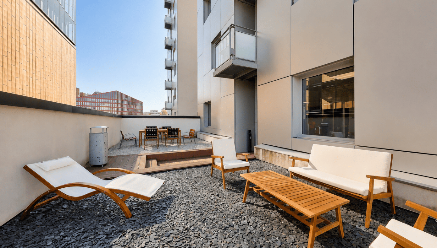 Terrasse extérieure de Part-Dieu Equinox avec assises en bois, table basse, bains de soleil et espace de détente.