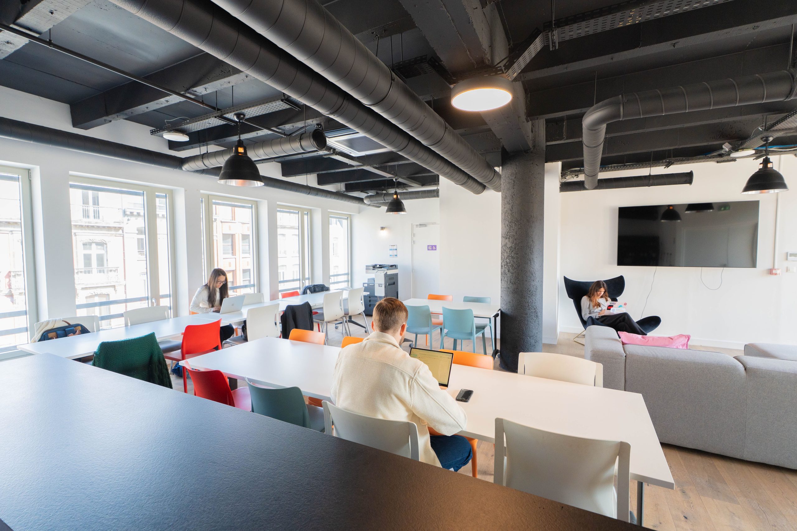 Espace commun lumineux avec mobilier coloré et coin détente chez Hiptown Grand Place à Lille – bureaux flexibles à louer en plein cœur du centre-ville, rue Nationale.