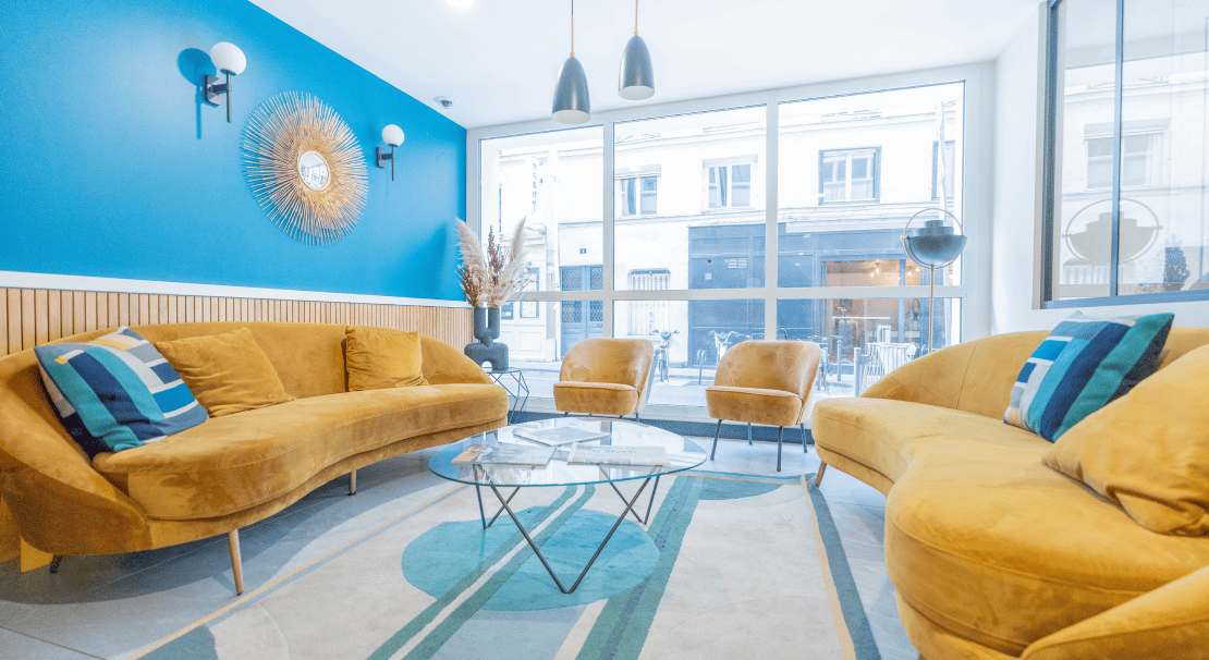 Espace de travail moderne chez Hiptown Place de la Bourse à Bordeaux avec des canapés, mobilier design et ambiance lumineuse