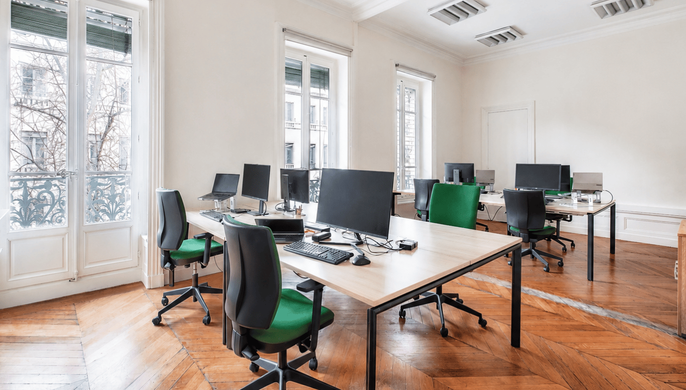 Bureau privatif Hiptown à Lyon avec plusieurs postes de travail, écrans, fauteuils et grandes fenêtres