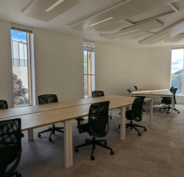 Intérieur d'un bureau moderne avec des postes de travail, des chaises ergonomiques et des étagères décoratives, espace de coworking HipTown