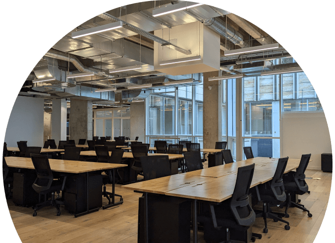 Intérieur d'un bureau moderne avec des postes de travail, des chaises noires et des luminaires suspendus, espace de coworking HipTown.