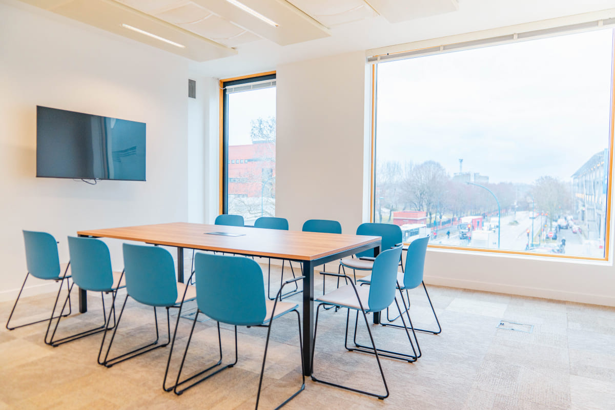 Salle de réunion moderne à louer à Pantin avec vue panoramique sur le Canal de l’Ourcq – bureaux flexibles Hiptown avec écran, mobilier design et lumière naturelle.