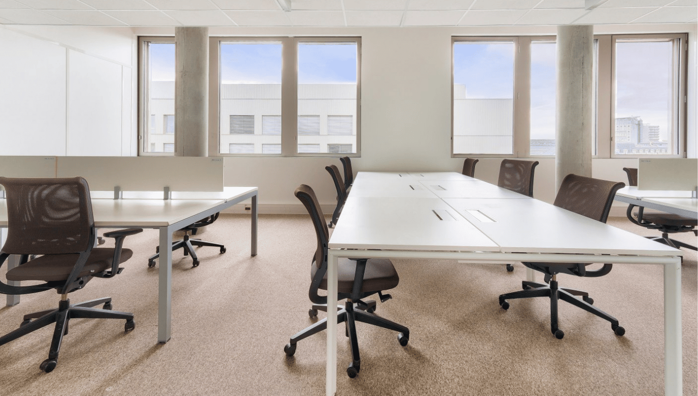 Bureau fermé Hiptown à Bordeaux avec plusieurs postes de travail, sièges de bureau et grandes fenêtres.