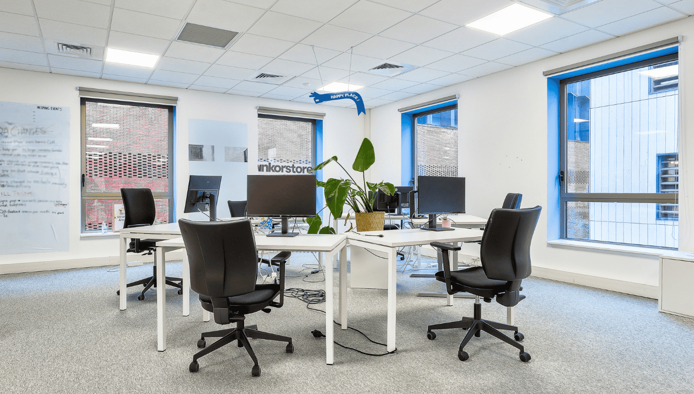 Espace de bureaux partagés Hiptown à Lille avec postes informatiques, sièges noirs et grandes fenêtres.