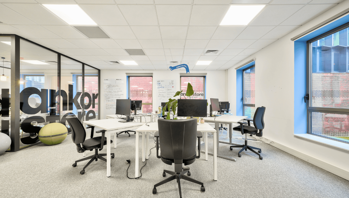 Bureau privatif Hiptown à Lille avec postes de travail, chaises noires, fenêtres et cloison vitrée.