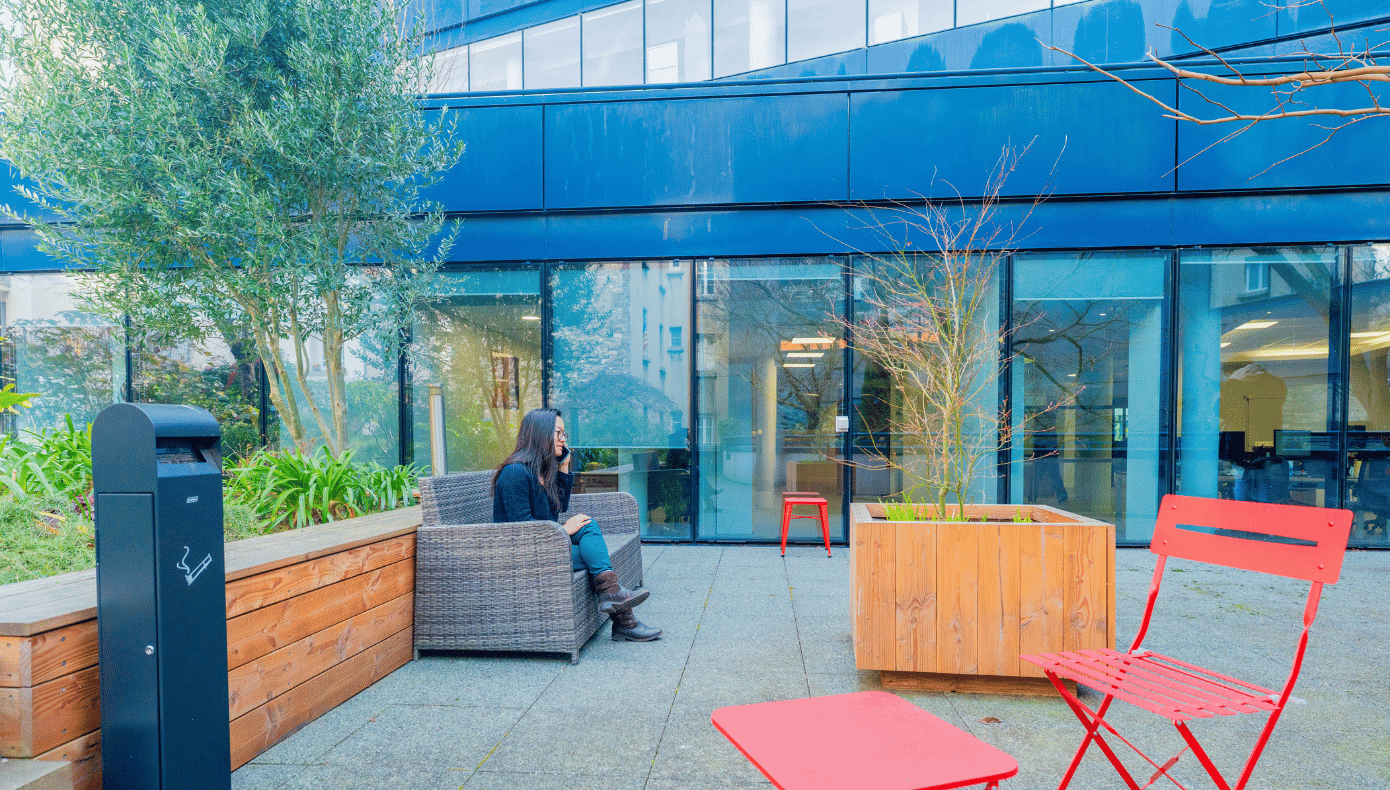 Espace extérieur de Hiptown Boulogne avec mobilier, jardinières et façade vitrée donnant sur les bureaux.