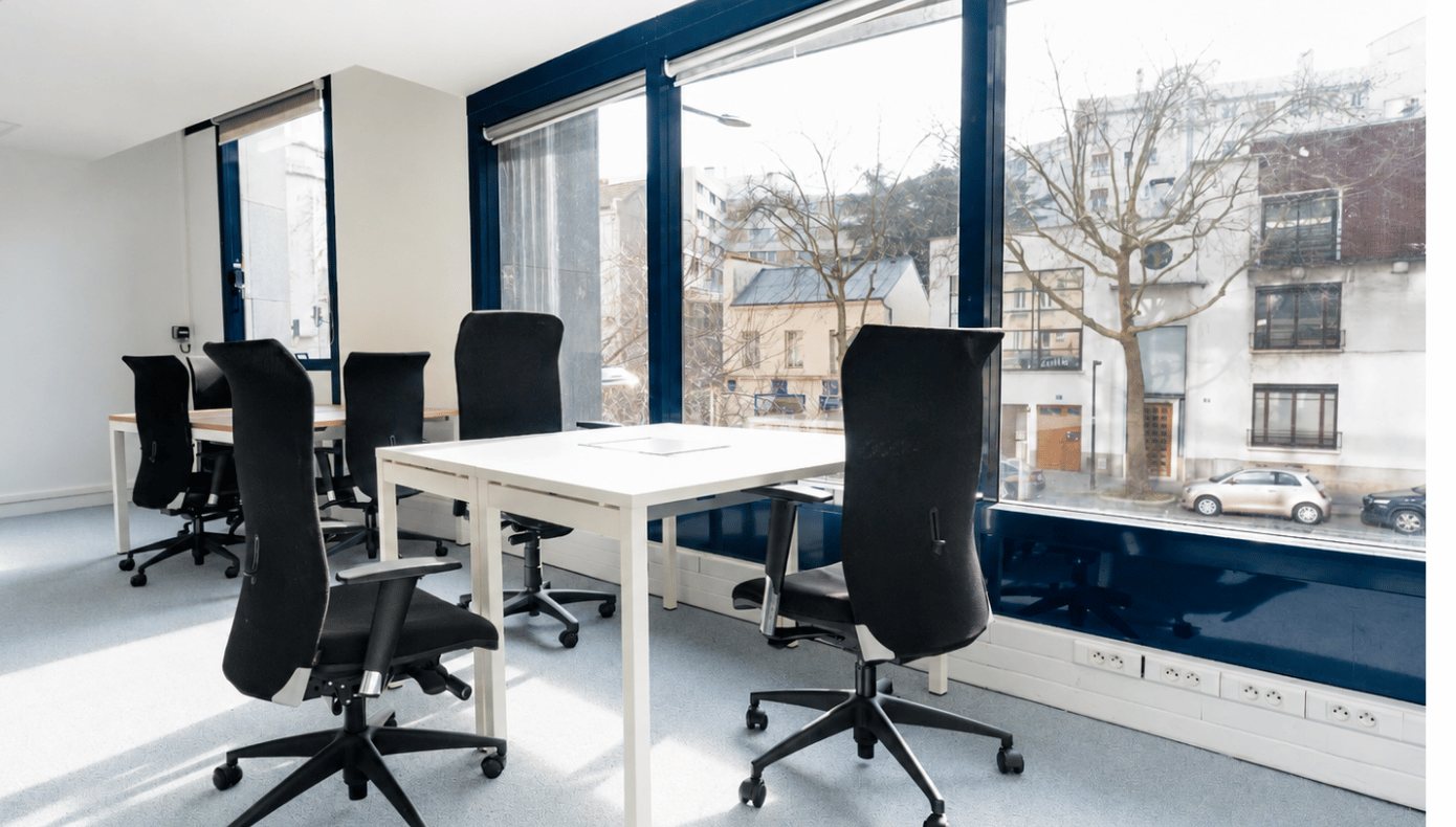 Bureau partagé à Hiptown Boulogne avec plusieurs postes de travail installés devant de grandes fenêtres.