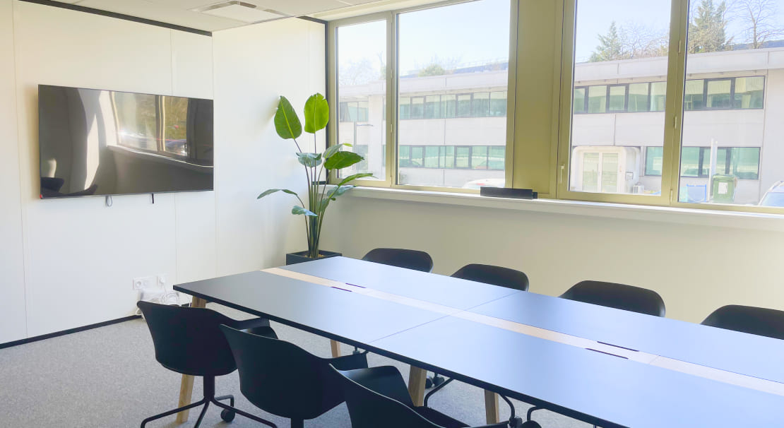 Salle de réunion moderne et lumineuse chez Hiptown Madera, 67 Avenue John Fitzgerald Kennedy à Mérignac 33700, équipée d'un écran et d'un mobilier confortable pour vos réunions d'équipe