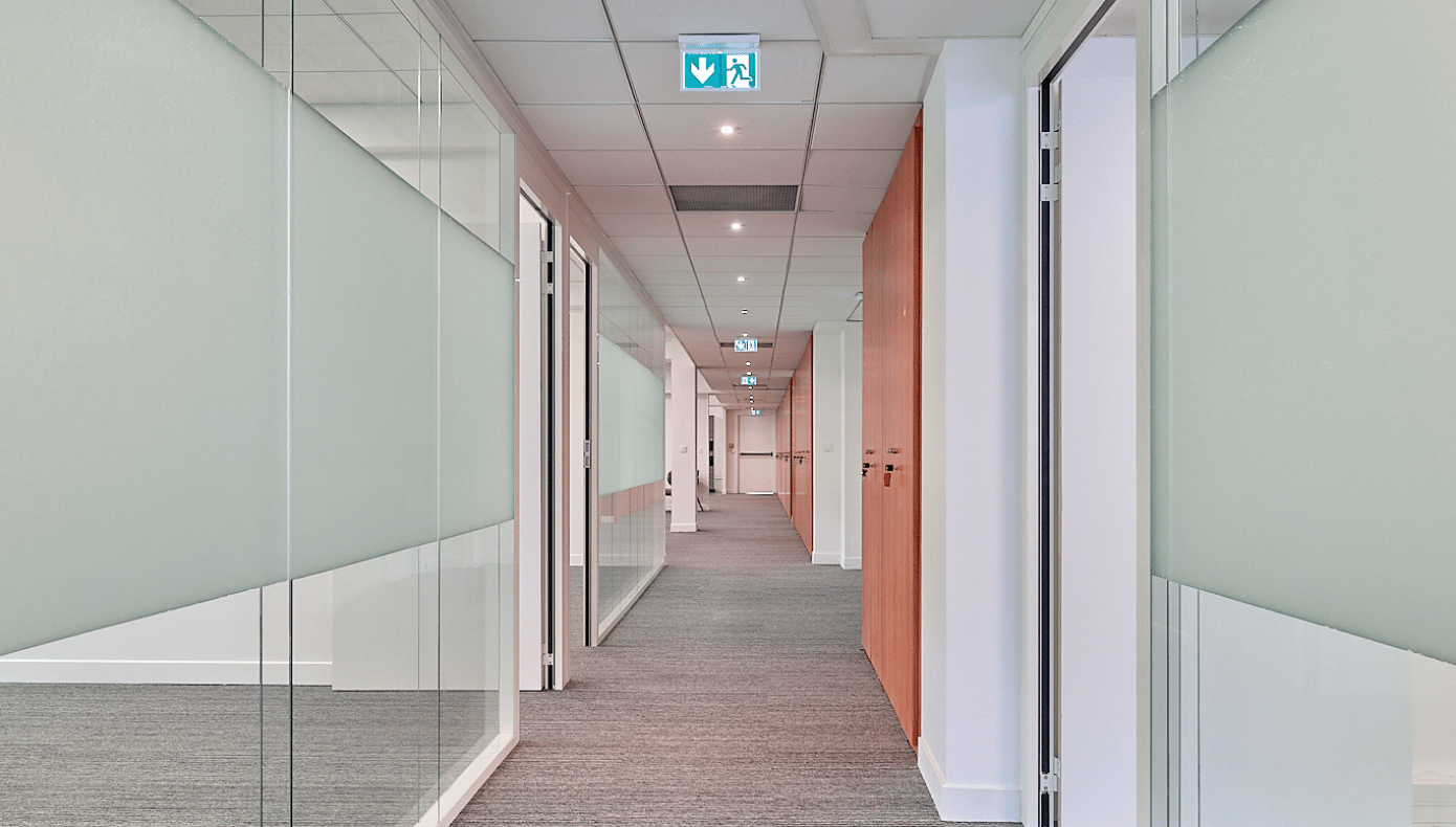 Couloir des bureaux de Hiptown Carnot Couloir desservant plusieurs bureaux vitrés avec cloisons partiellement dépolies à Hiptown Carnot, à Saint-Cloud.