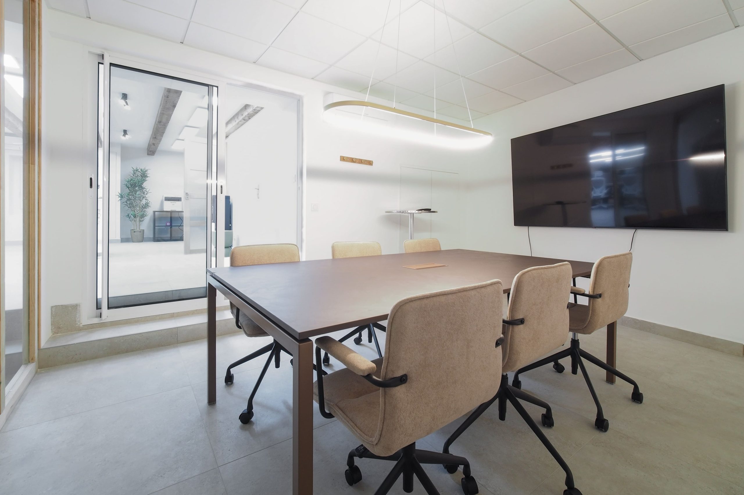 Salle de réunion moderne et lumineuse à Hiptown Arcole Marseille, équipée d’un écran et de mobilier ergonomique.
