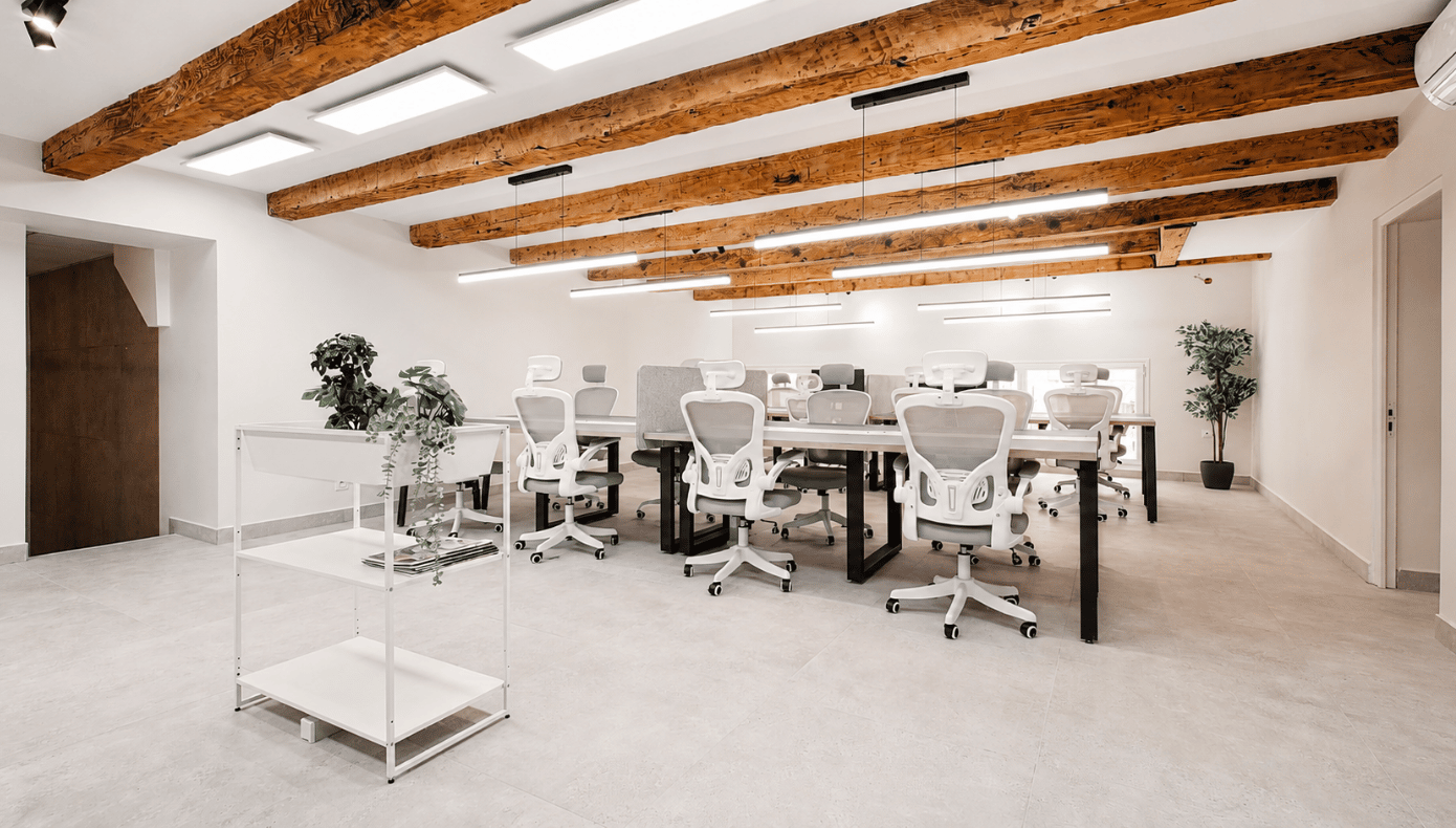 hiptown_bureaux_operes_marseille_open_space_rue_arcole Open space de bureaux opérés Hiptown rue d’Arcole à Marseille, avec plusieurs postes de travail et poutres en bois apparentes.