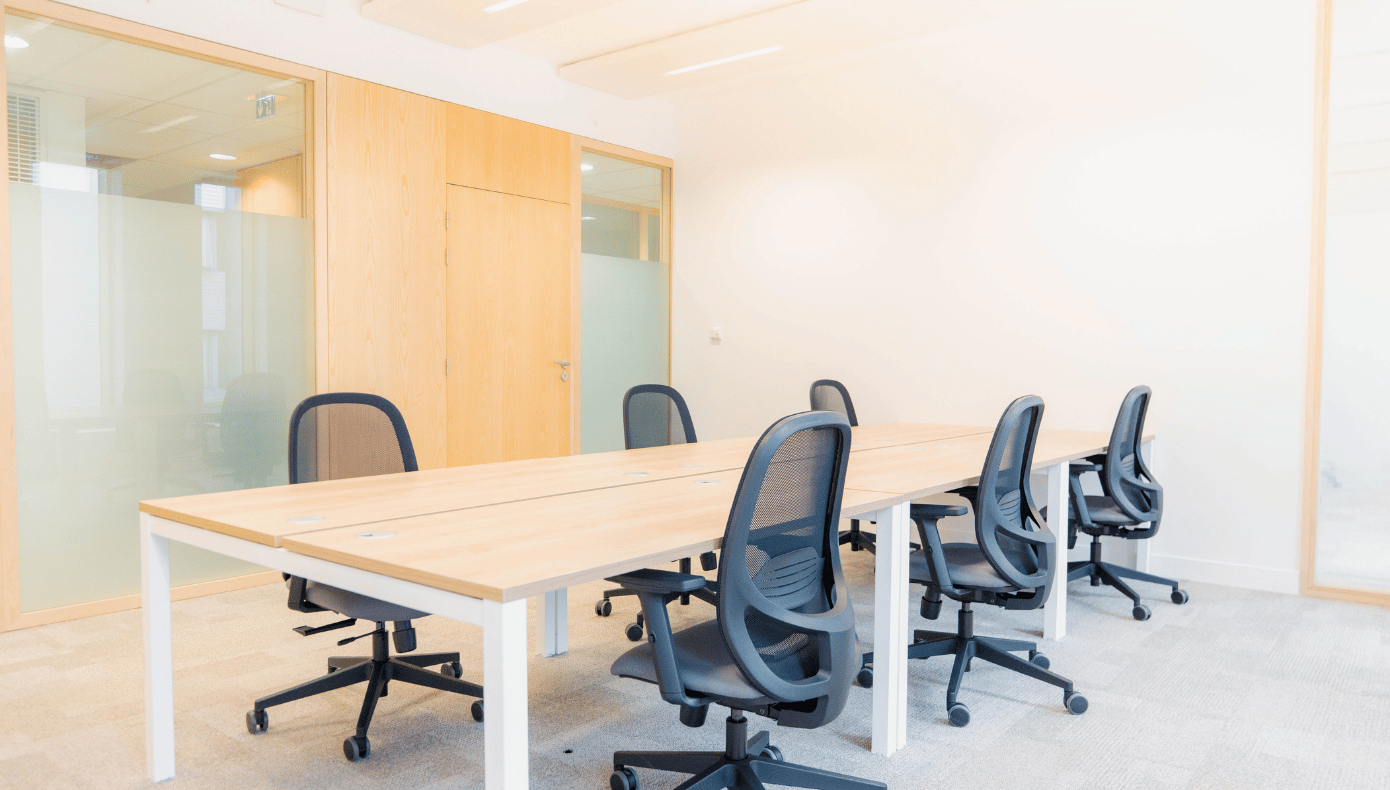 Bureau fermé à Pantin avec tables de travail, fauteuils à roulettes et cloisons vitrées.