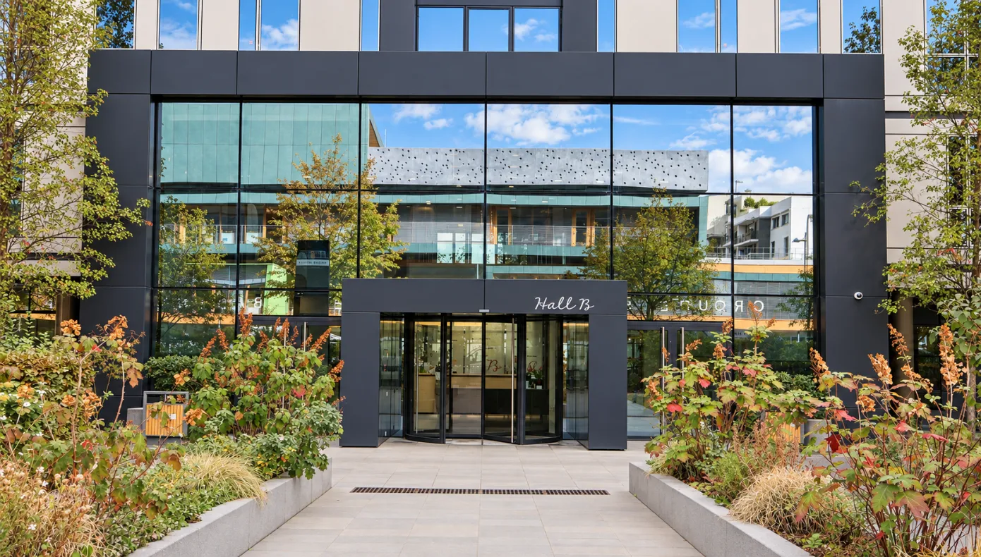 Façade extérieure du bâtiment Hiptown Front Office à Asnières-sur-Seine Façade vitrée du bâtiment accueillant Hiptown Front Office à Asnières-sur-Seine, avec entrée Hall B et espaces végétalisés.
