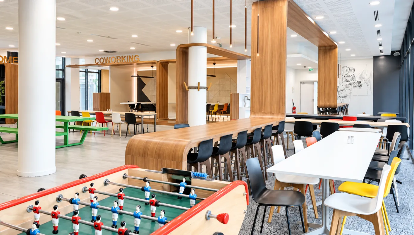 Espace commun avec coin repas à Asnières-sur-Seine Espace commun avec tables, assises et coin repas au sein de Hiptown Front Office à Asnières-sur-Seine.
