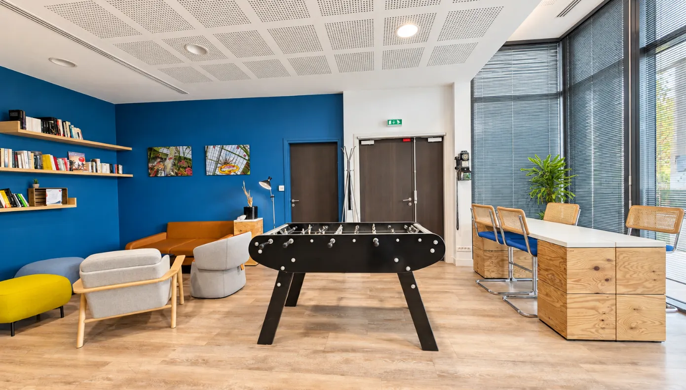 Espace détente avec baby-foot à Asnières-sur-Seine Espace détente avec baby-foot, assises lounge et coin lecture au sein de Hiptown Front Office à Asnières-sur-Seine.